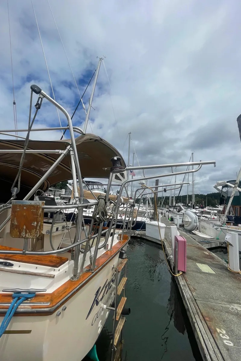Slide: The Image of 1995 Island Packet 40 sailboat docked at marina under cloudy sky. - 17
