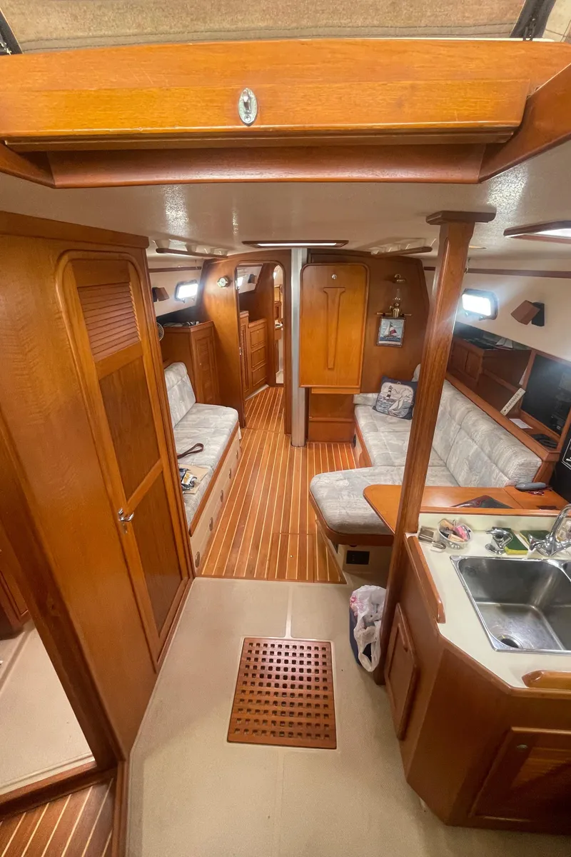 Slide: The Image of Interior of 1995 Island Packet 40 sailboat with wooden finishes and cozy seating area. - 18