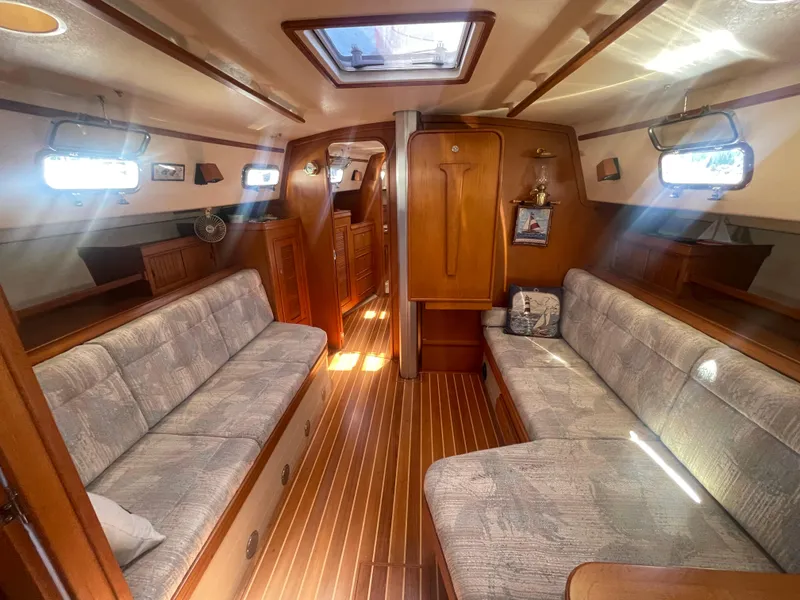 Slide: The Image of Interior of 1995 Island Packet 40 sailboat with wooden finishes and cushioned seating. - 20