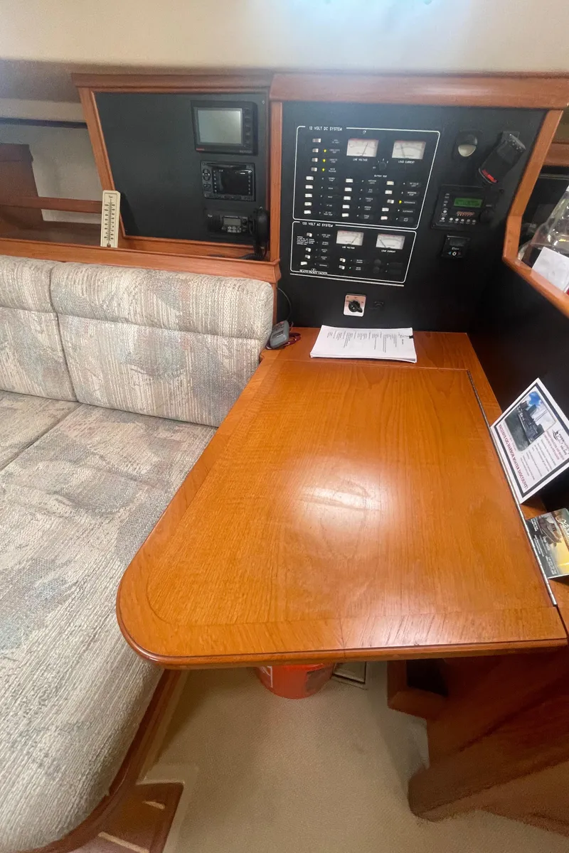 Slide: The Image of Navigation station of a 1995 Island Packet 40 sailboat with control panels and seating. - 23