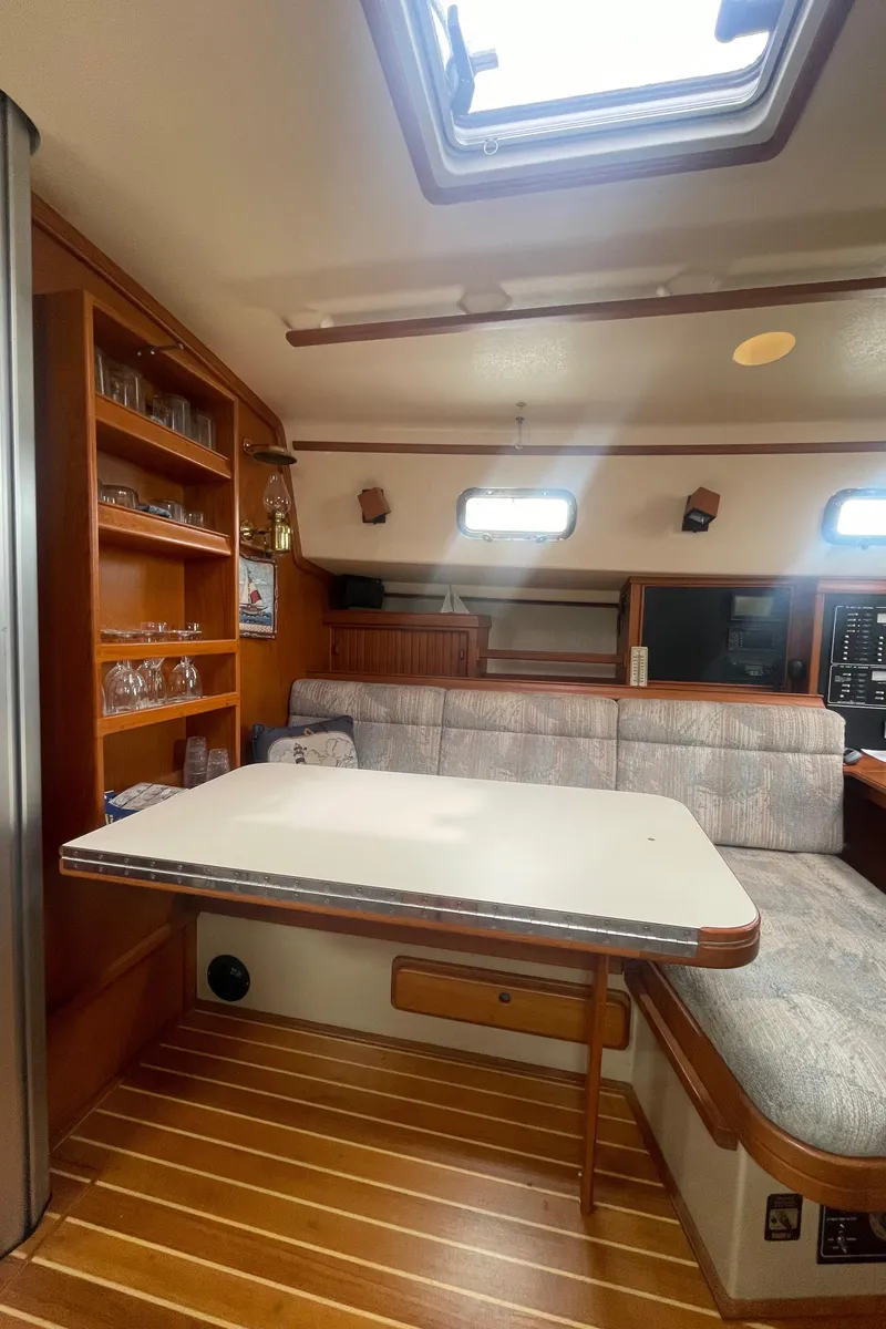 Slide: The Image of Interior of 1995 Island Packet 40 sailboat with dining area and wooden shelving. - 24