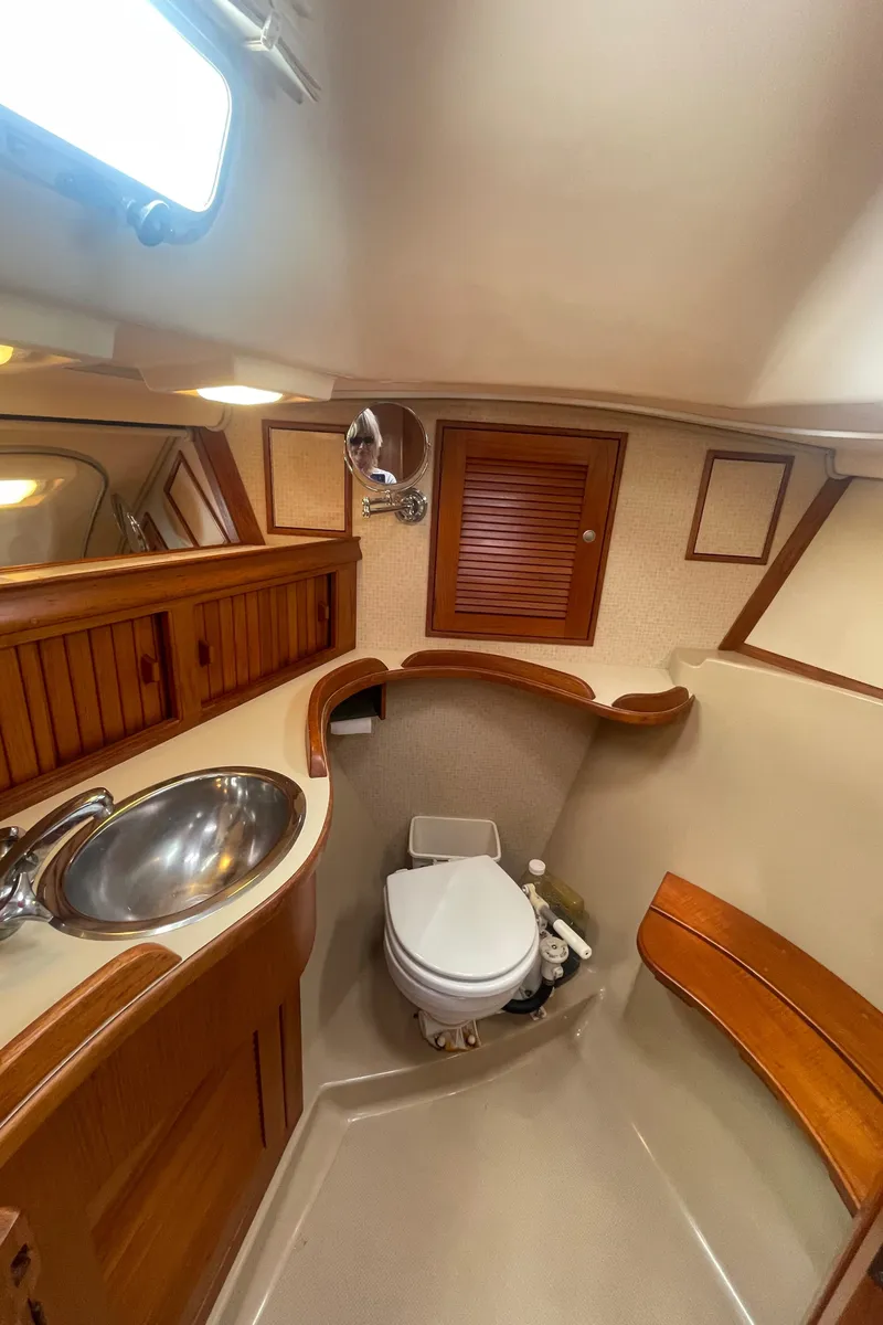 Slide: The Image of 1995 Island Packet 40 yacht bathroom with wooden cabinetry and stainless steel sink. - 31
