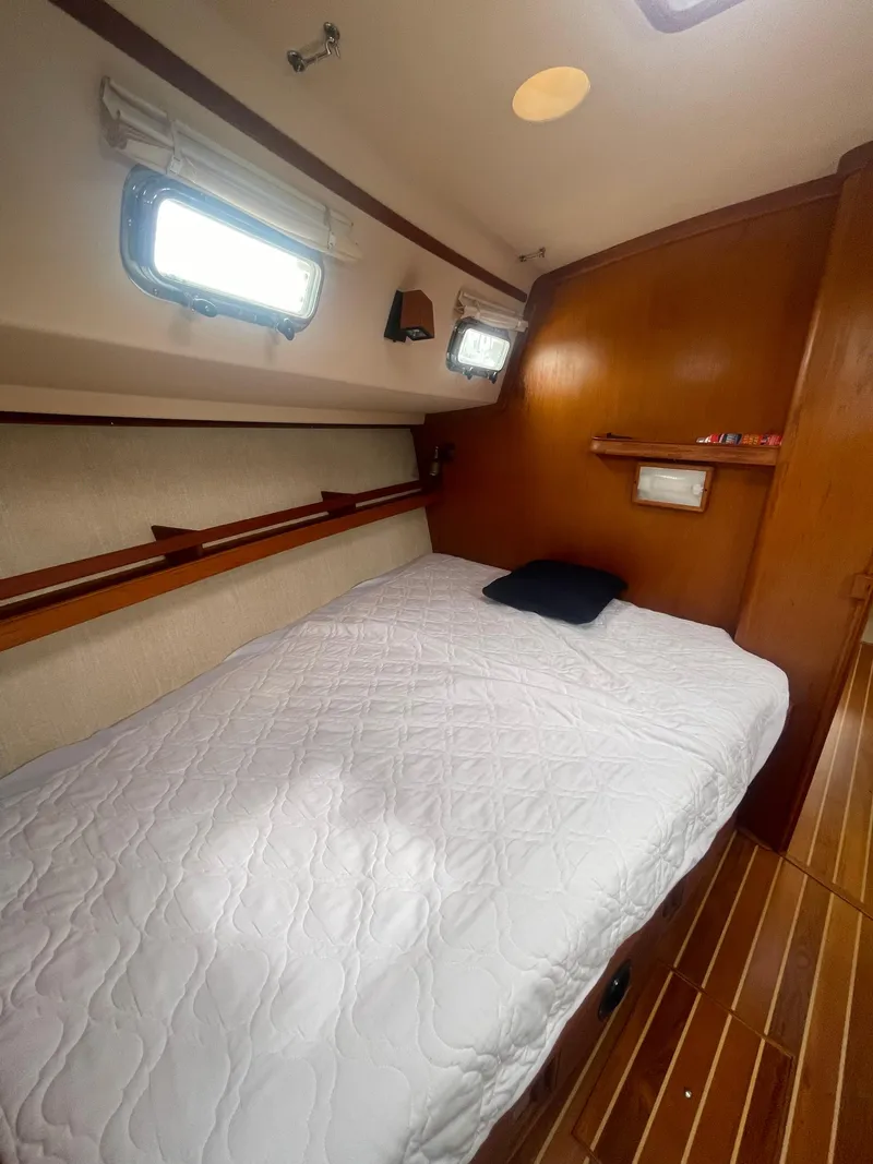 Slide: The Image of Cozy cabin interior of 1995 Island Packet 40 sailboat with bed and wooden accents. - 33