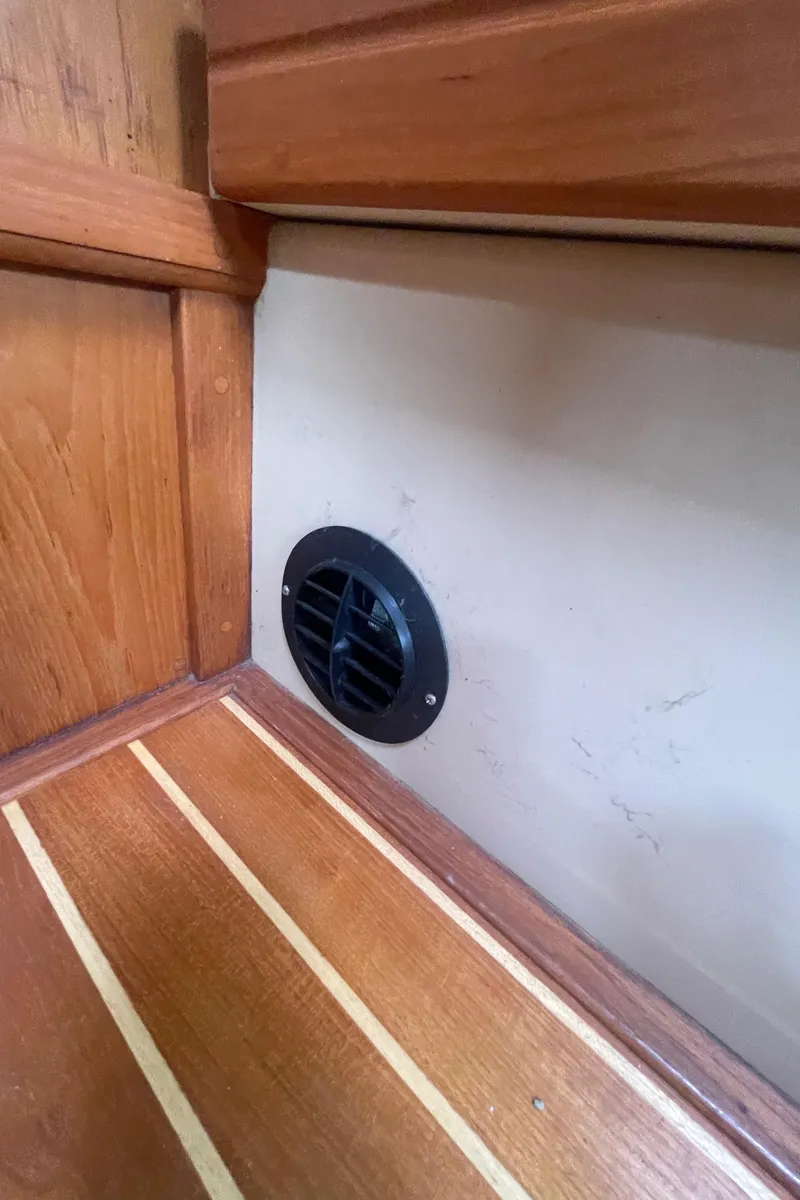 Slide: The Image of Wooden interior of a 1995 Island Packet 40 sailboat with a circular vent. - 35