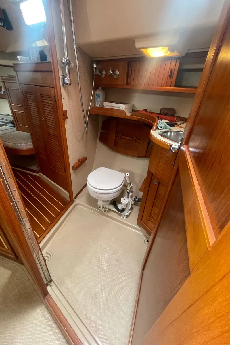 Slide: The Image of 1995 Island Packet 40 yacht bathroom with wooden cabinetry, toilet, and sink. - 41