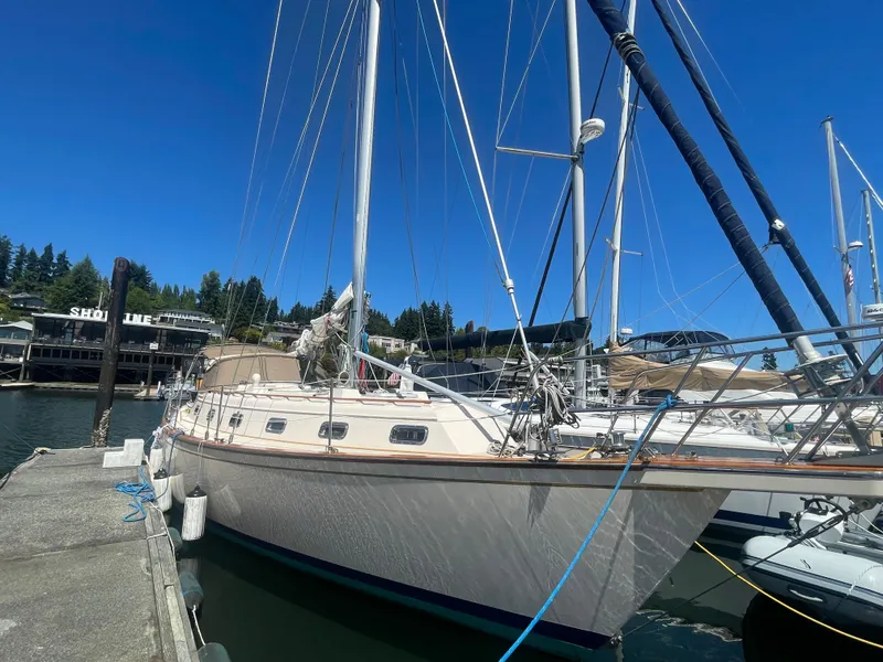 Slide: The Image of 1995 Island Packet 40 sailboat docked at marina under clear blue sky. - 46