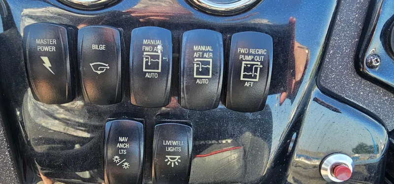 Slide: The Image of Control panel of a 2022 Tracker Tagra V19 boat with various switches. - 16