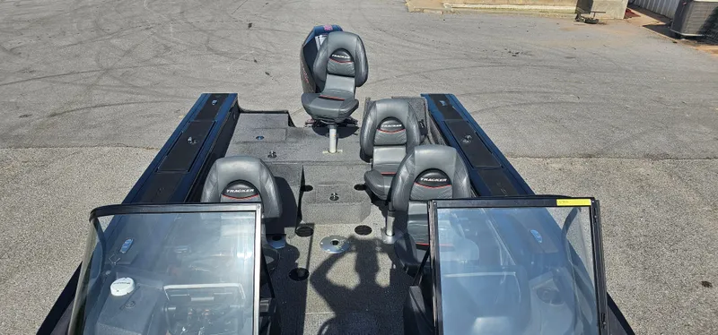 Slide: The Image of 2022 Tracker Tagra V19 boat interior with seating and dual windshields on a concrete surface. - 7