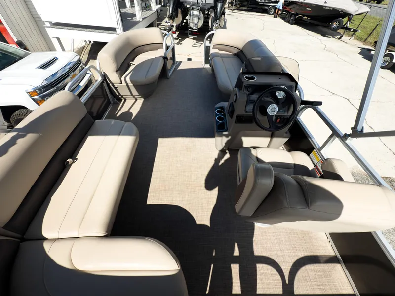 Slide: The Image of 2025 Sun Tracker Party Barge 16 DLX interior with beige seating and steering console. - 13