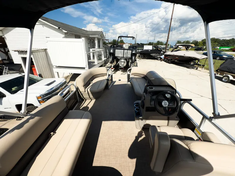 Slide: The Image of 2025 Sun Tracker Party Barge 16 DLX pontoon boat with beige seating and steering console. - 17