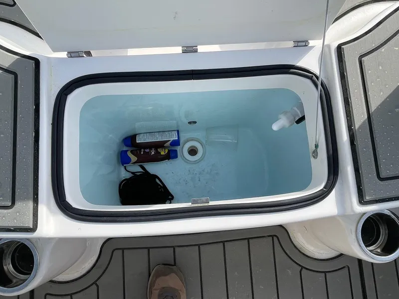 Slide: The Image of 2024 Robalo R200 Center Console livewell with storage items on deck. - 12