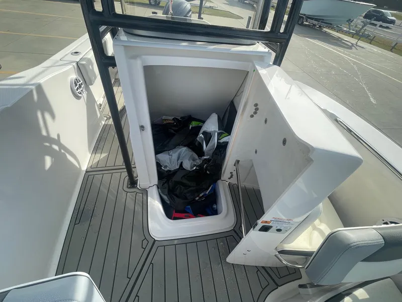 Slide: The Image of 2024 Robalo R200 Center Console boat storage compartment open, showing interior space. - 15