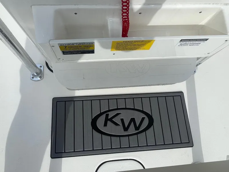 Slide: The Image of 2024 Key West 189 FS boat interior with KW logo mat and capacity label. - 14