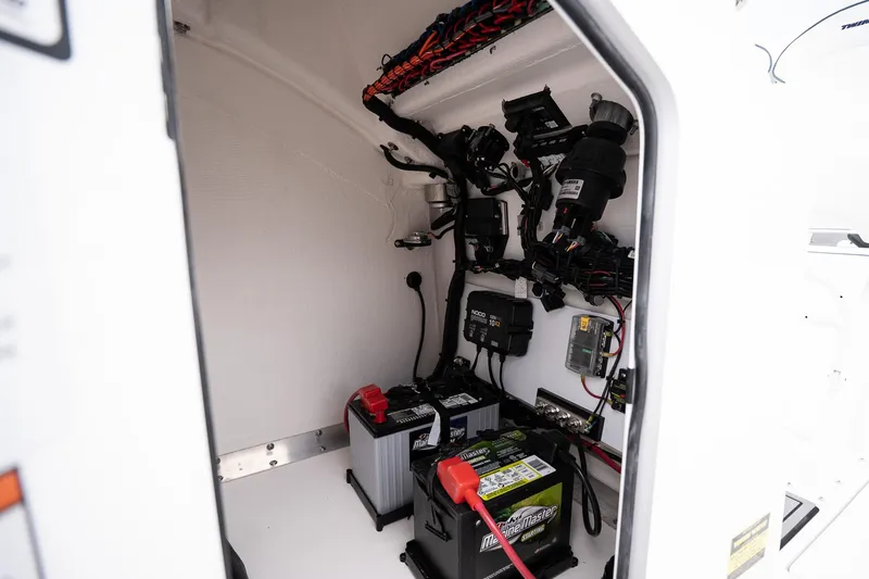 Slide: The Image of Electrical compartment of 2026 Twin Vee 22 Bay Cat boat with batteries and wiring. - 19