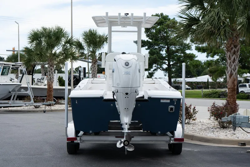 Slide: The Image of 2026 Twin Vee 22 Bay Cat boat on trailer, parked near palm trees. - 5