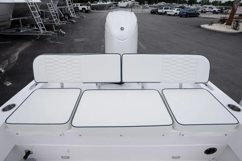 Slide: The Image of 2026 Twin Vee 22 Bay Cat boat with white cushioned seating in a marina setting. - 9