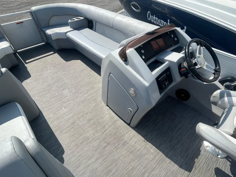 Slide: The Image of 2021 Bennington 23L pontoon boat interior with gray seating and steering console. - 15