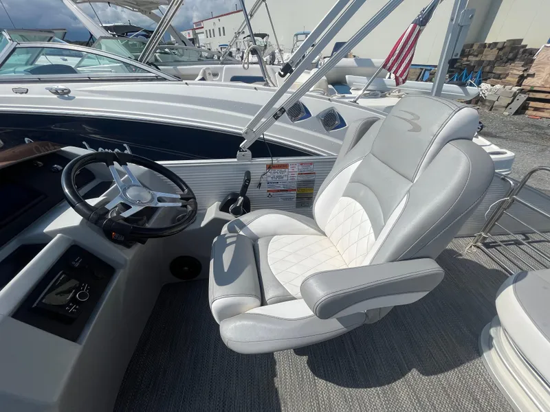 Slide: The Image of Captain's seat and steering wheel of a 2021 Bennington 23L boat, featuring luxurious upholstery. - 16