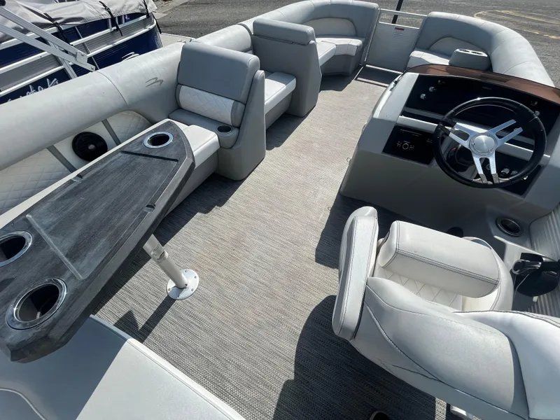 Slide: The Image of 2021 Bennington 23L pontoon boat interior with seating and steering wheel. - 18