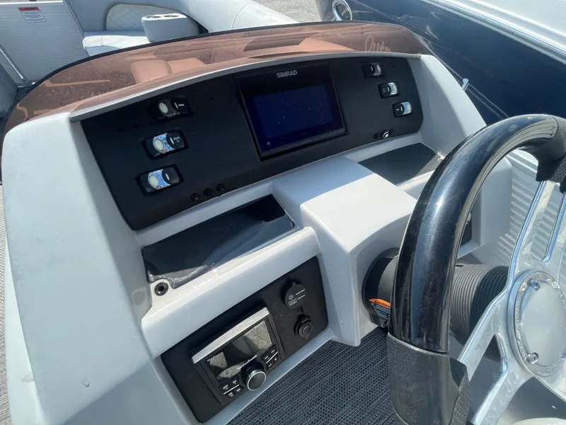 Slide: The Image of 2021 Bennington 23L boat dashboard with steering wheel and control panel. - 21