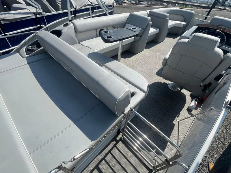Slide: The Image of 2021 Bennington 23L pontoon boat interior with gray seating and table. - 22