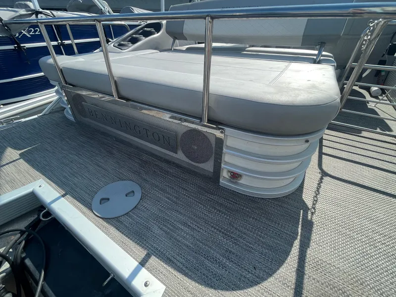Slide: The Image of 2021 Bennington 23L pontoon boat with cushioned seating and stainless steel railings. - 24