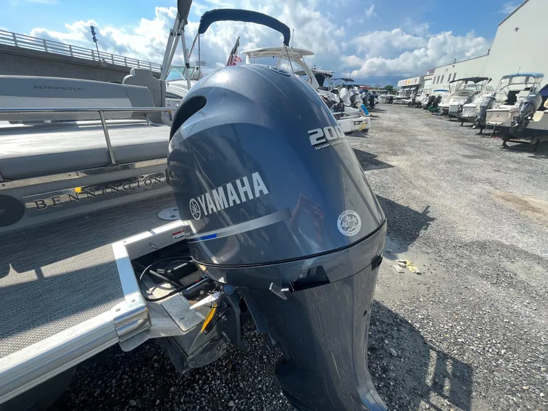 Slide: The Image of 2021 Bennington 23L boat with Yamaha 200 engine in a marina setting. - 25
