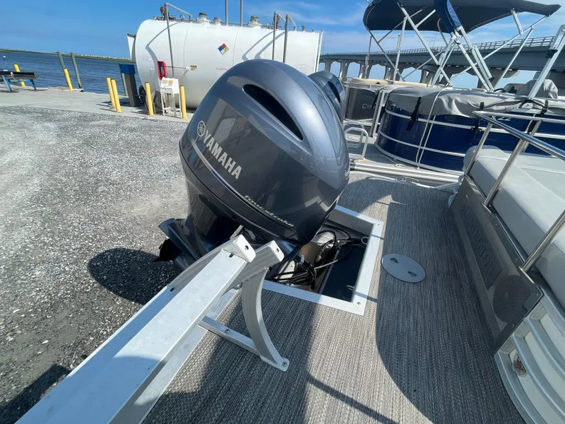 Slide: The Image of 2021 Bennington 23L pontoon boat with Yamaha outboard motor at a dockside location. - 26