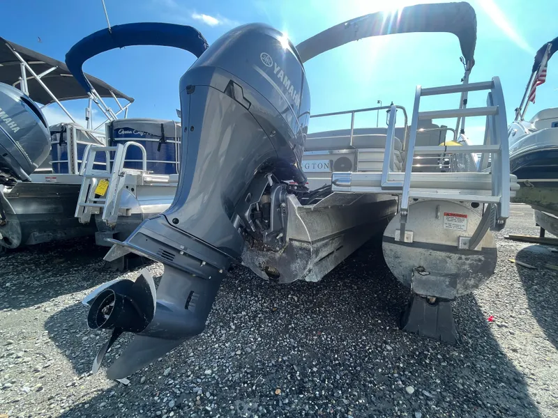Slide: The Image of 2021 Bennington 23L pontoon boat with Yamaha outboard motor, docked on gravel. - 27