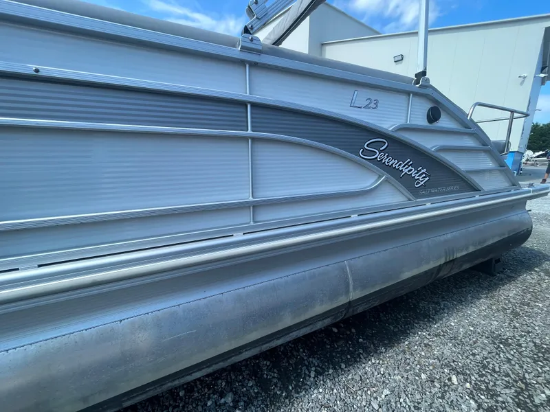 Slide: The Image of 2021 Bennington 23L pontoon boat, "Serendipity," in a marina setting. - 3