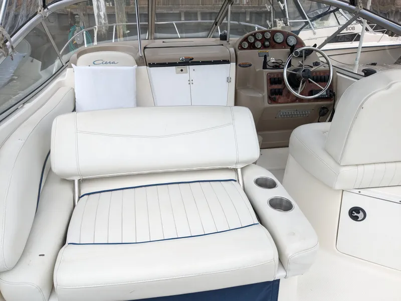 Slide: The Image of 2002 Bayliner 245 Ciera boat interior with white seating and control panel. - 10