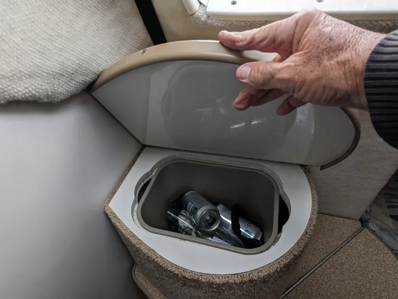Slide: The Image of Hand opening storage compartment on 2002 Bayliner 245 Ciera boat interior. - 13