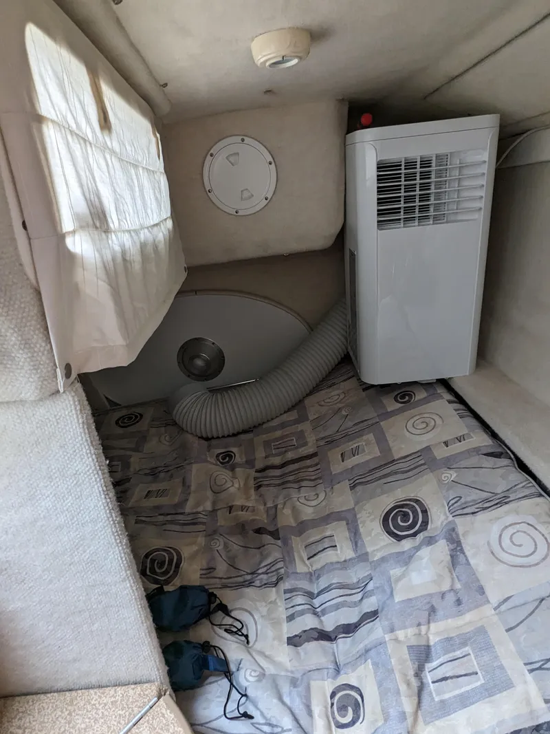 Slide: The Image of Interior of a 2002 Bayliner 245 Ciera with air conditioning unit and patterned bedding. - 16
