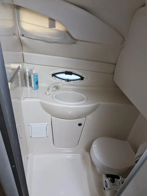 Slide: The Image of 2002 Bayliner 245 Ciera boat bathroom with sink, toilet, and small window. - 17