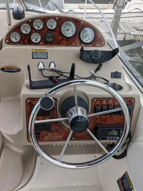 Slide: The Image of Control panel of a 2002 Bayliner 245 Ciera boat with gauges and steering wheel. - 7