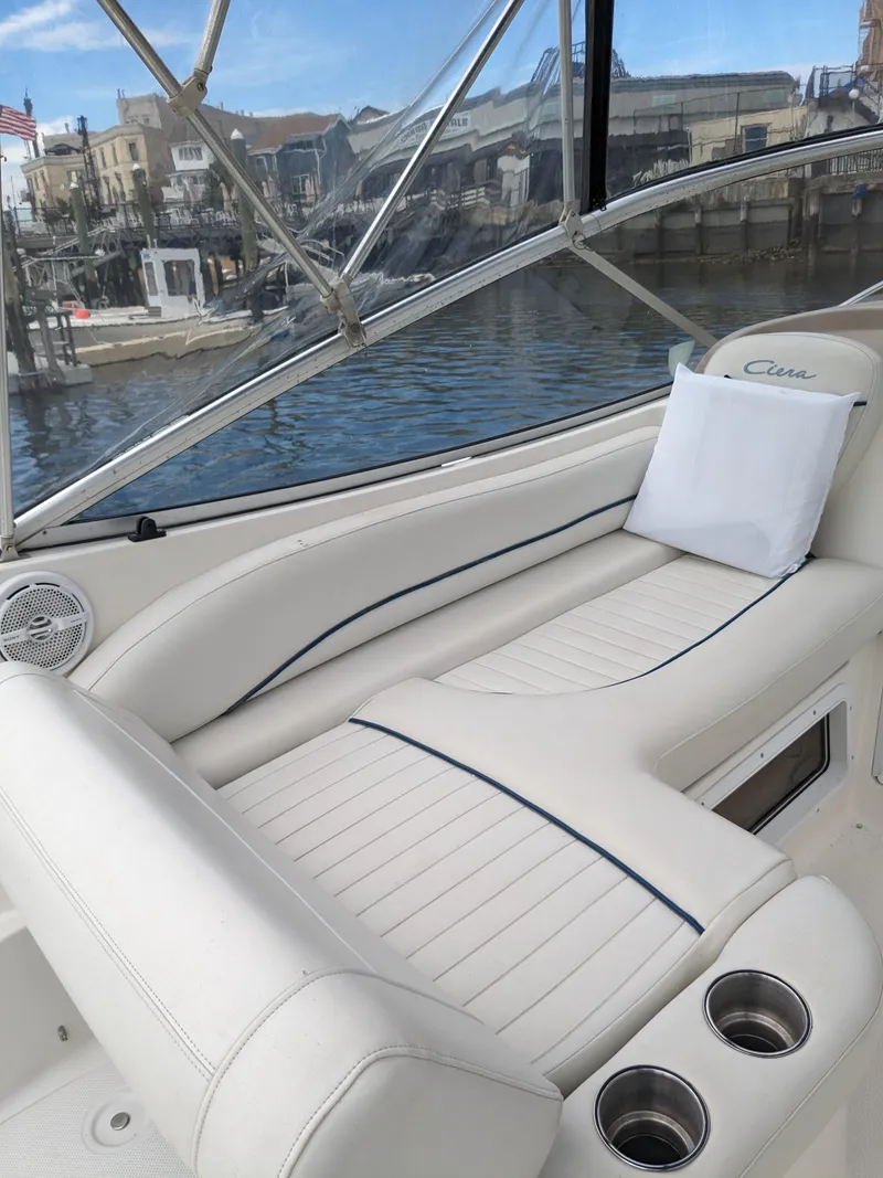 Slide: The Image of Interior of a 2002 Bayliner 245 Ciera boat with white seating and cup holders. - 9