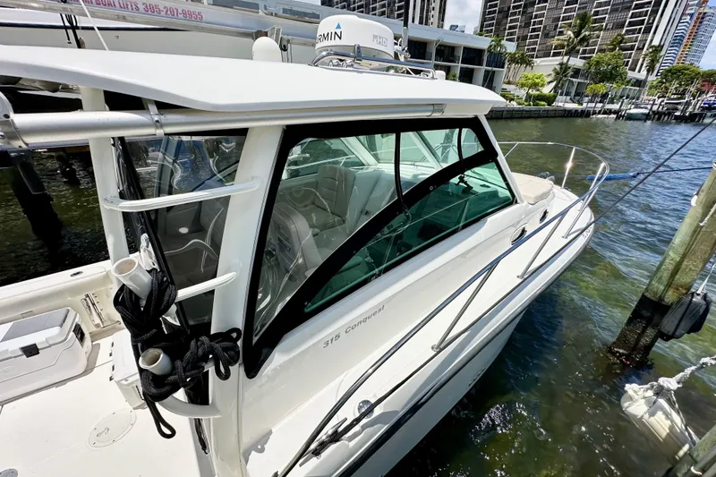 Slide: The Image of 2015 Boston Whaler 315 Conquest docked, showcasing sleek design and modern features. - 10