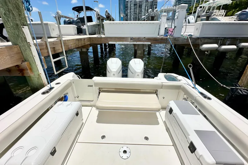 Slide: The Image of 2015 Boston Whaler 315 Conquest docked, showcasing spacious deck and twin engines. - 15