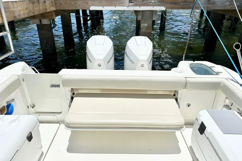 Slide: The Image of 2015 Boston Whaler 315 Conquest boat with twin Mercury engines at dock. - 16