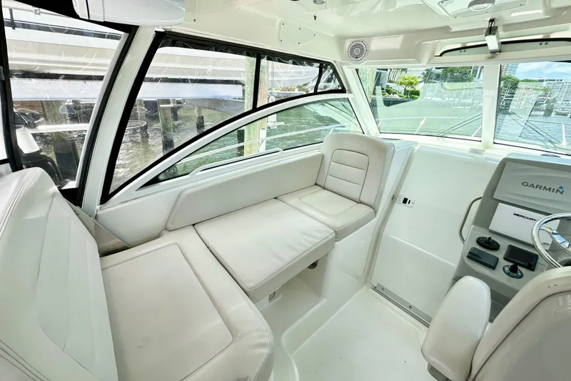 Slide: The Image of 2015 Boston Whaler 315 Conquest interior with white seating and Garmin navigation system. - 22
