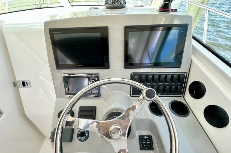 Slide: The Image of Control panel of 2015 Boston Whaler 315 Conquest with dual Garmin displays and steering wheel. - 23