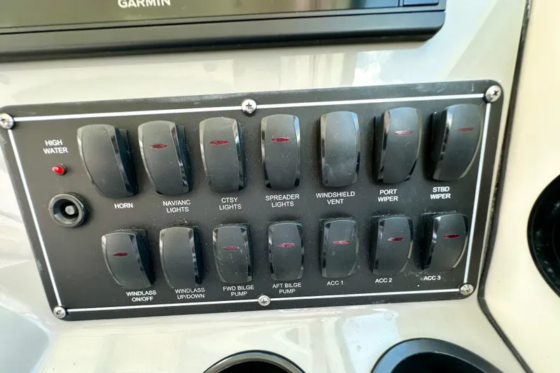 Slide: The Image of Control panel of a 2015 Boston Whaler 315 Conquest boat with labeled switches. - 24