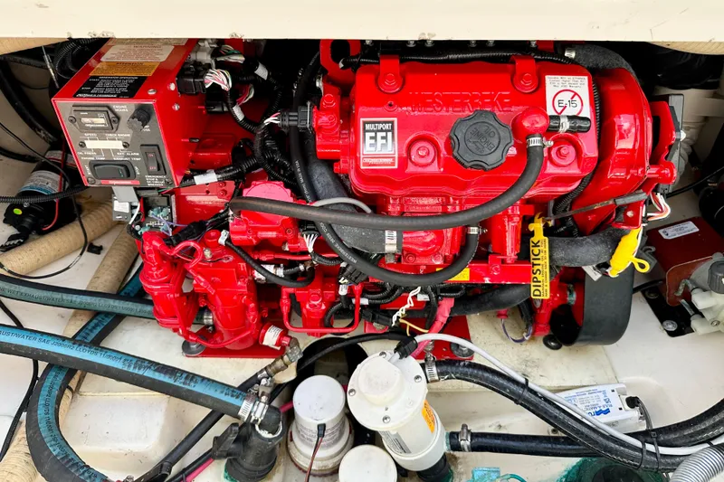 Slide: The Image of Engine compartment of a 2015 Boston Whaler 315 Conquest, featuring a red multiport EFI engine. - 37