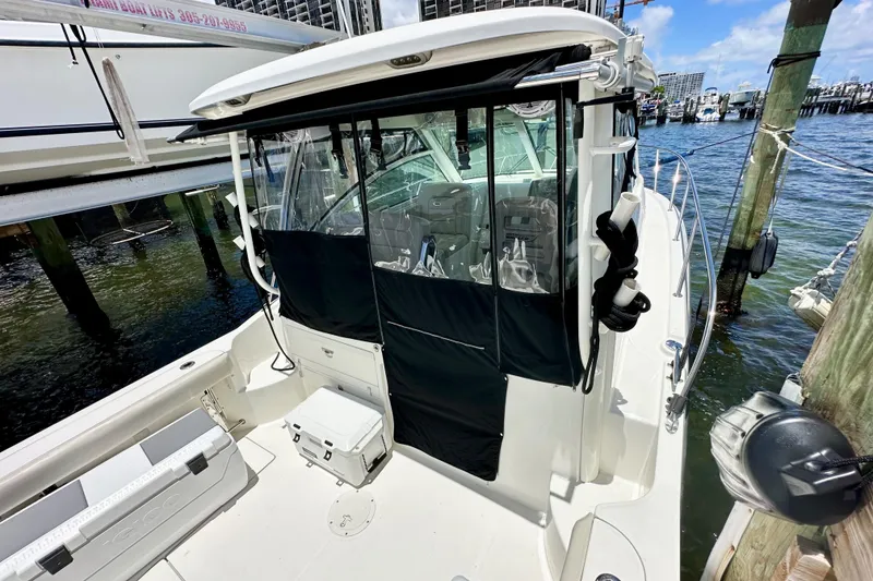 Slide: The Image of 2015 Boston Whaler 315 Conquest docked, showcasing cockpit and cabin area. - 7