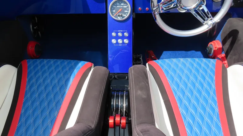 Slide: The Image of Interior of 1995 Talon 36 Cat with blue diamond-stitched seats and chrome steering wheel. - 12