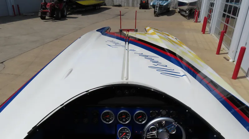 Slide: The Image of 1995 Talon 36 Cat boat with colorful graphics, dashboard, and steering wheel in a marina setting. - 16