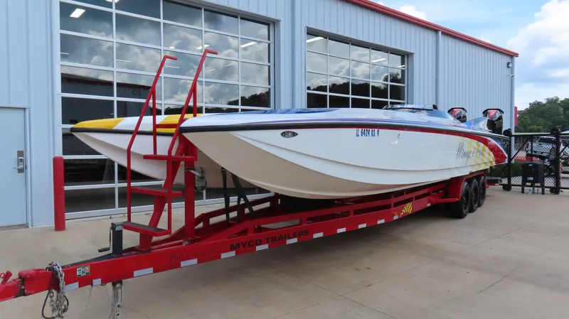 Slide: The Image of 1995 Talon 36 Cat powerboat on red trailer outside a garage. - 24