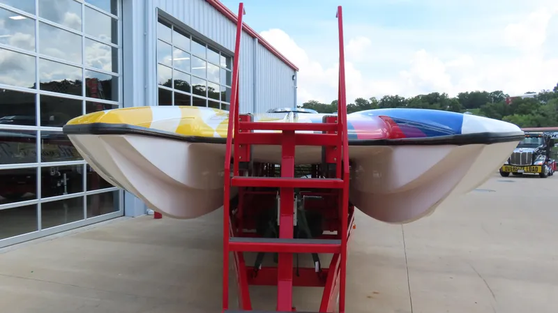 Slide: The Image of 1995 Talon 36 Cat powerboat with vibrant colors, displayed outside a garage. - 25