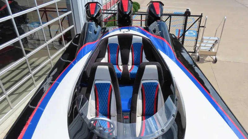 Slide: The Image of 1995 Talon 36 Cat powerboat with blue and red interior, docked near a glass building. - 8