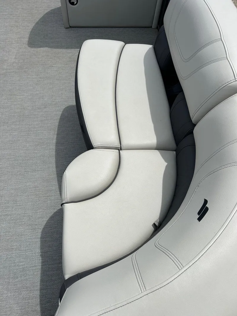 Slide: The Image of 2022 Starcraft CX21 boat interior with curved white and gray seating. - 18